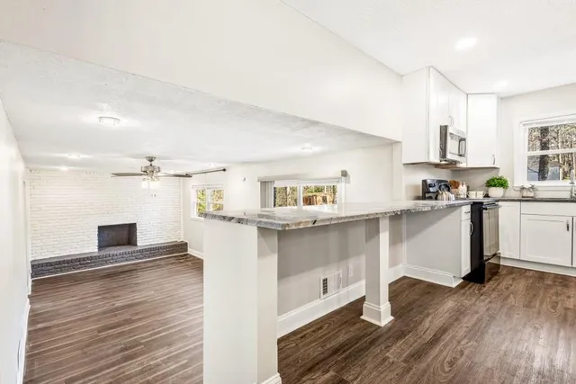 a kitchen with cabinets and wooden floor