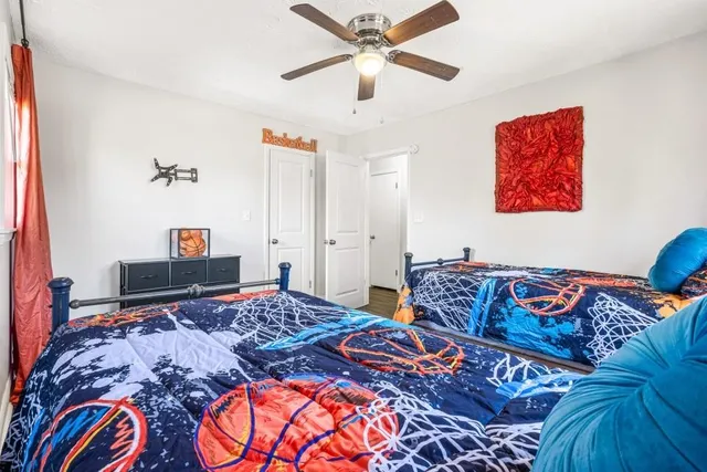 a bedroom with a large bed and a chandelier
