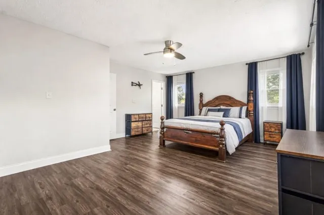 a bedroom with a bed and wooden floor