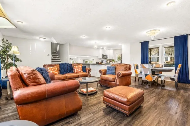 a living room with furniture kitchen view and a table