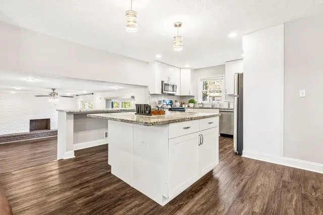 a kitchen with kitchen island a sink and a stove top oven