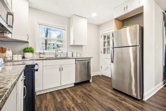 a kitchen with a refrigerator sink and cabinets