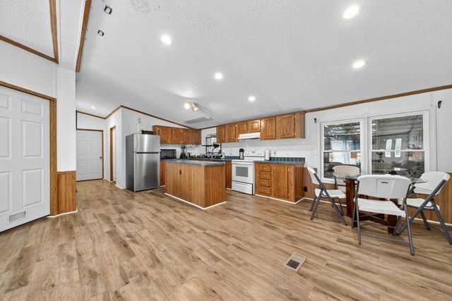 a living room with furniture kitchen view and a wooden floor