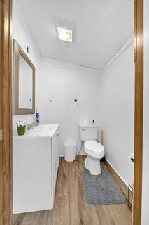 a bathroom with a sink a toilet a mirror and shower