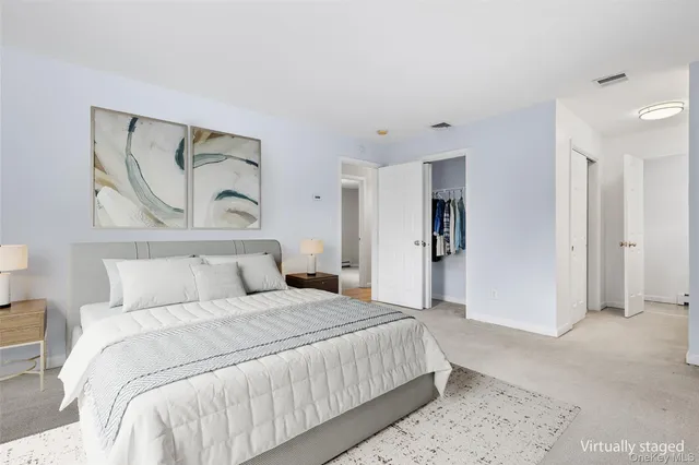 a bedroom with a large bed and painting on the wall