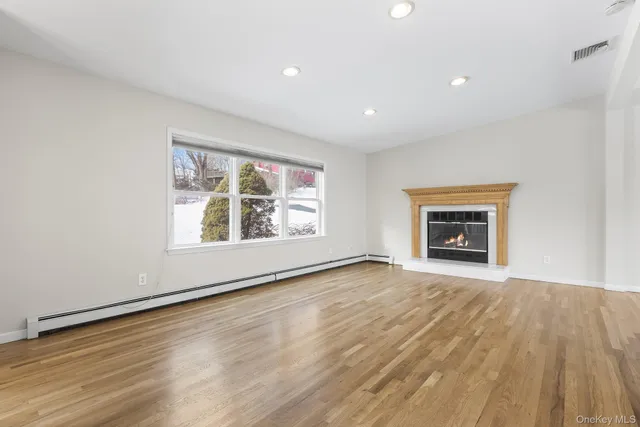 wooden floor fireplace and windows in an empty room