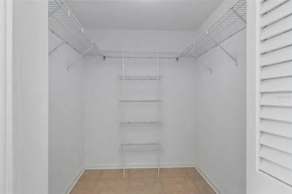 an empty room with a ceiling fan and carpet