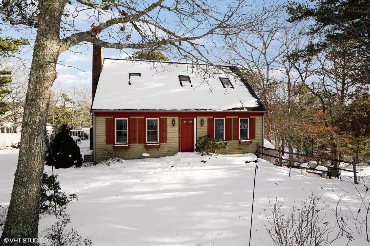 60 Ridge St Extension Wellfleet, MA 02667 - Photo 21 of 21 a front view of a house with a yard covered with snow