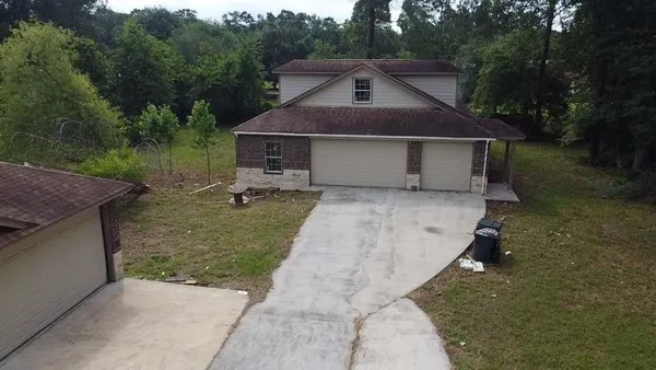 a front view of house with yard and trees in the background