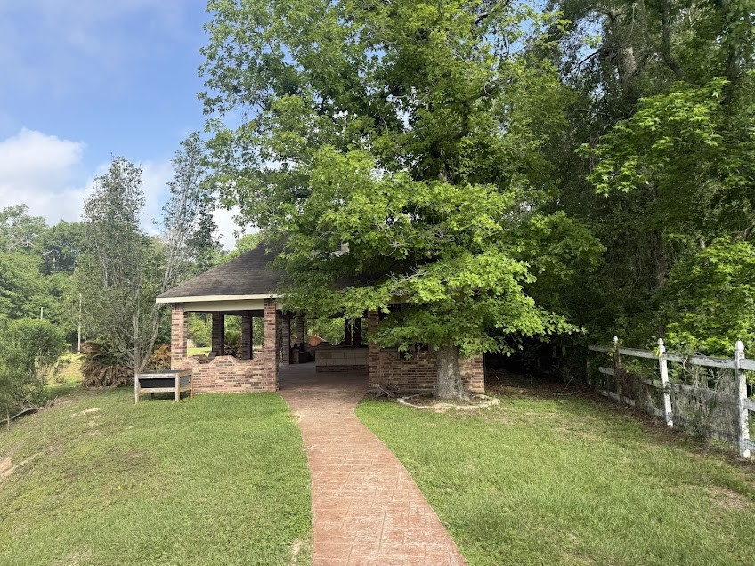 11529 Warner Road Cleveland, TX 77328 - Photo 24 of 27 a view of a patio with table and chairs potted plants and a large tree