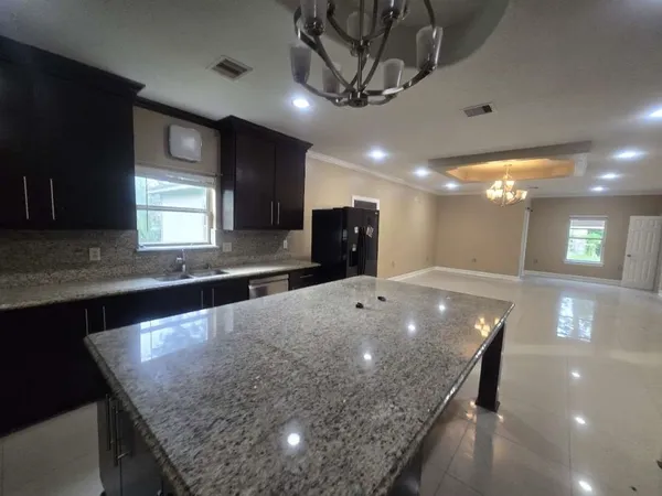 a large kitchen with stainless steel appliances a large counter top