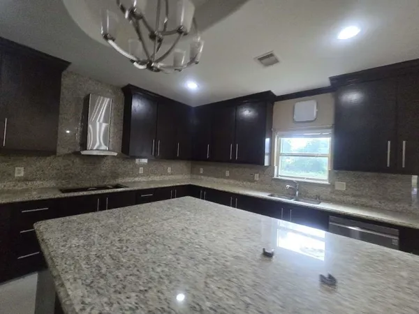 a large kitchen with stainless steel appliances a large counter top