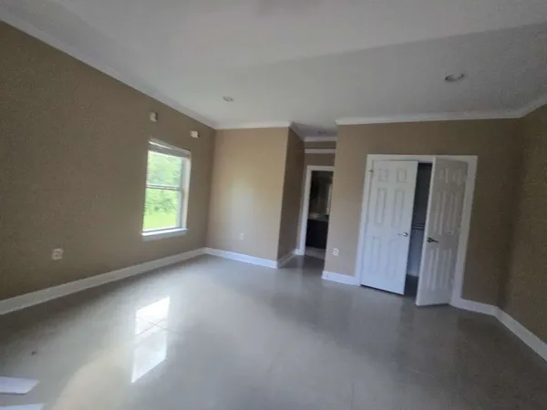 an empty room with closet and a window