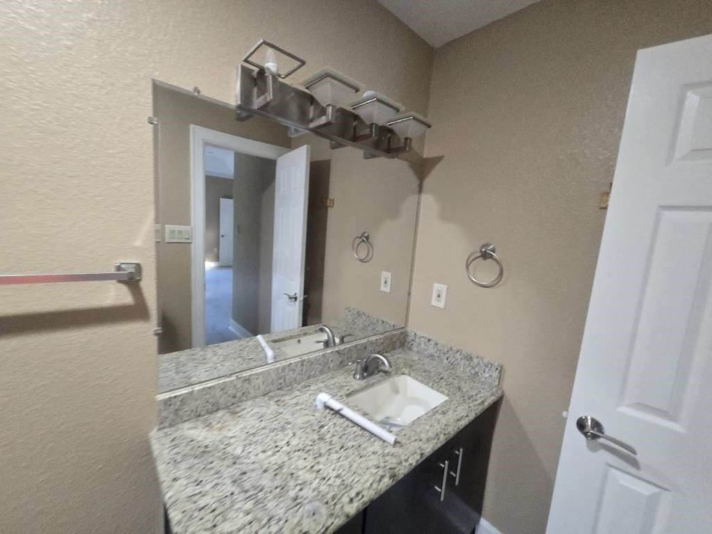 11529 Warner Road Cleveland, TX 77328 - Photo 10 of 27 a bathroom with a granite countertop sink and a mirror