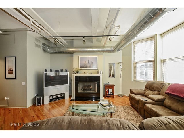 500 South Clinton Street, Unit 603 Chicago, IL 60607 - Photo 3 of 10 a living room with furniture a flat screen tv and a fireplace