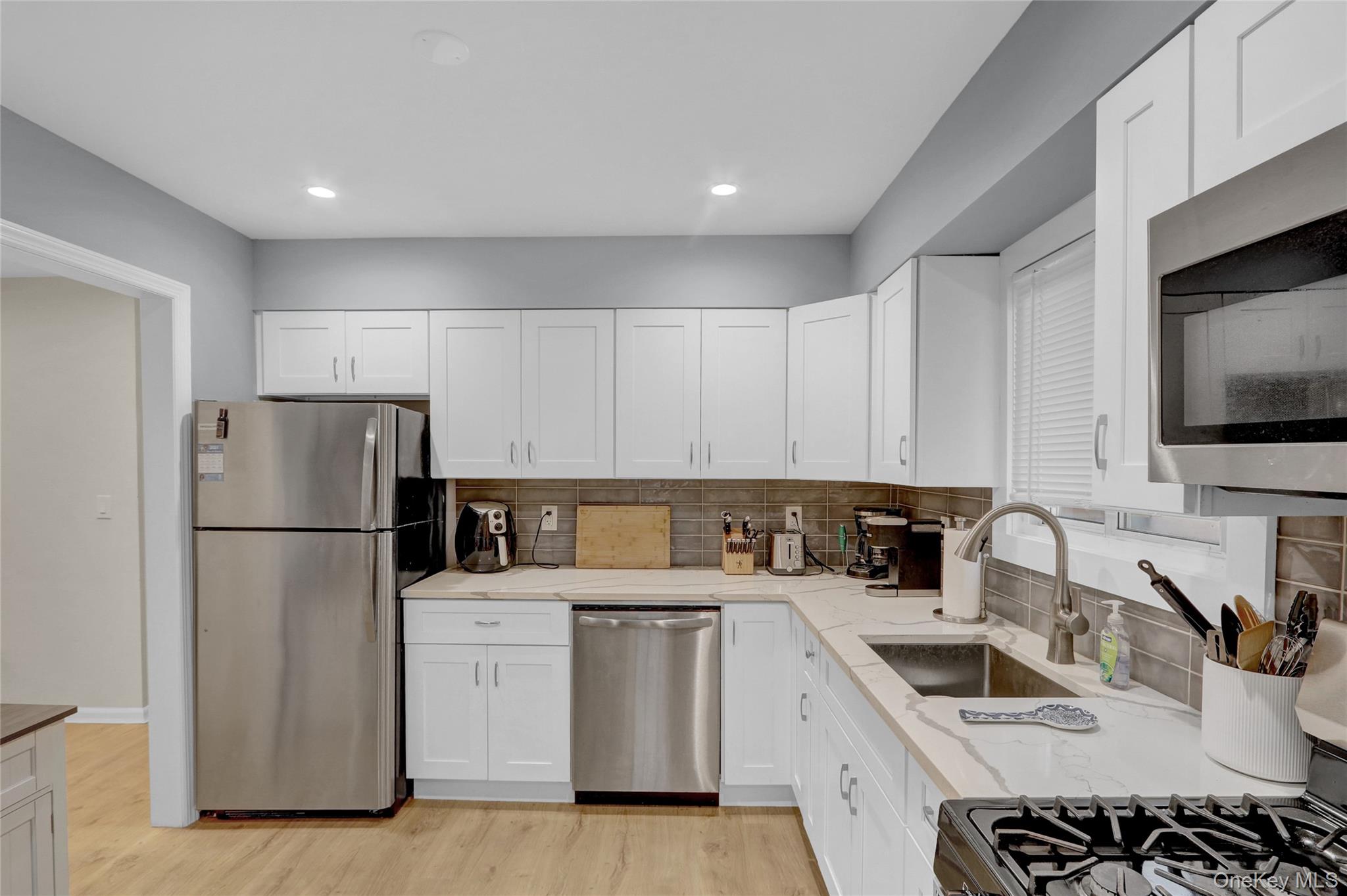 220 East Chester Street Long Beach, NY 11561 - Photo 15 of 26 a kitchen with a sink a refrigerator and a stove top oven