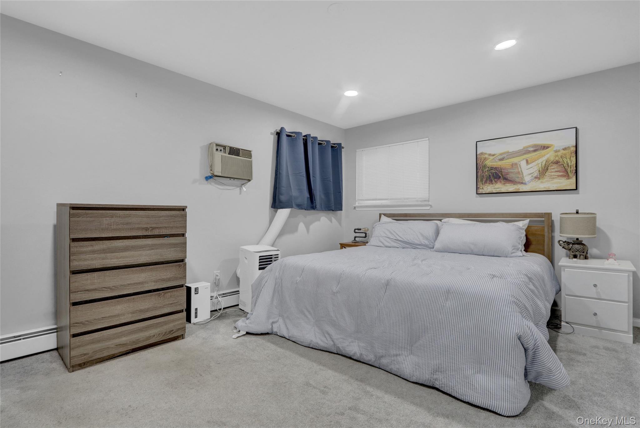 220 East Chester Street Long Beach, NY 11561 - Photo 18 of 26 a spacious bedroom with a bed and a painting on the wall