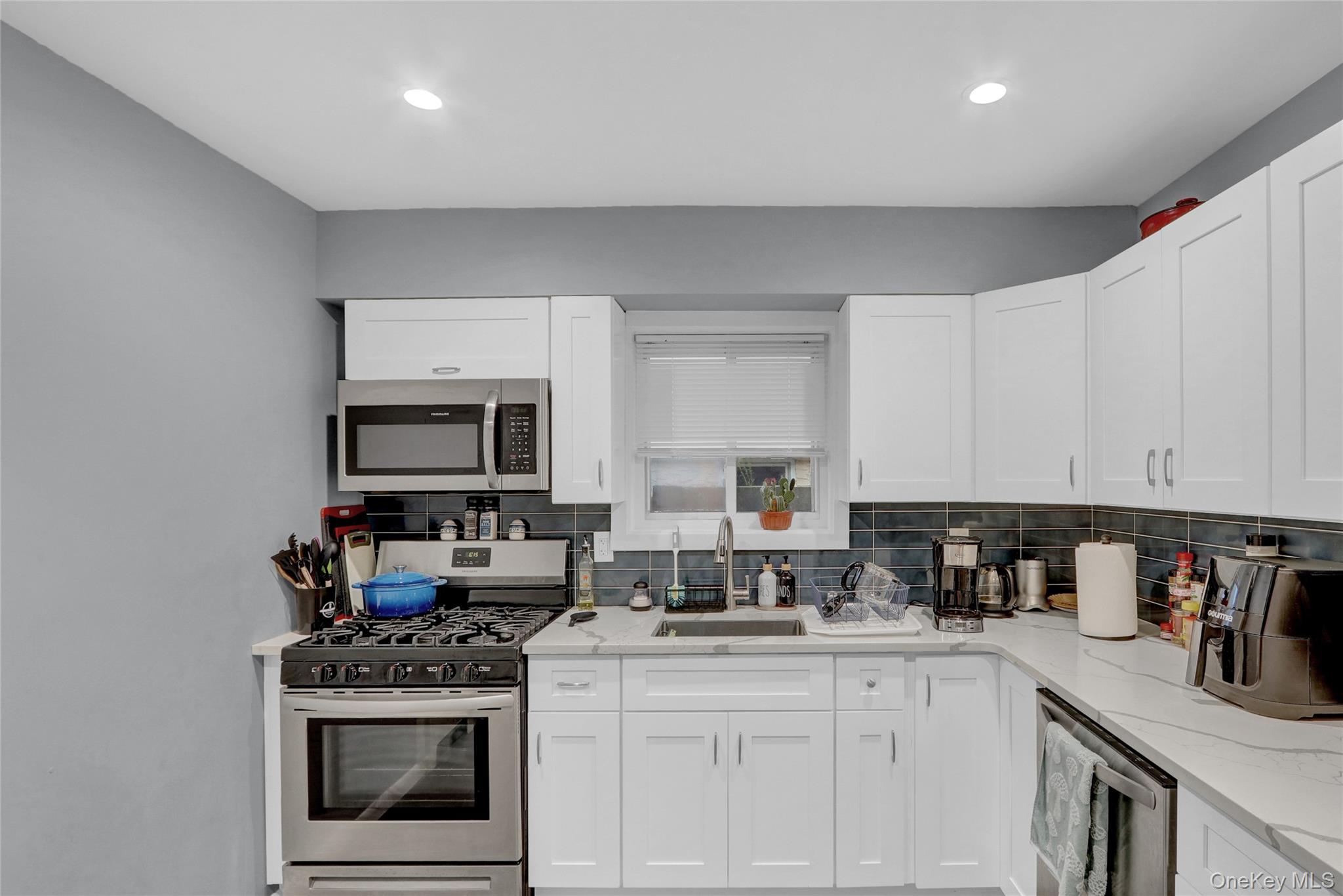 220 East Chester Street Long Beach, NY 11561 - Photo 6 of 26 a kitchen with stainless steel appliances granite countertop a stove top oven a sink dishwasher and white cabinets
