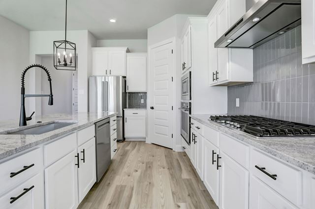 17309 Howdy Way Manor, TX 78653 - Photo 3 of 12 a kitchen with granite countertop a stove a sink and a refrigerator
