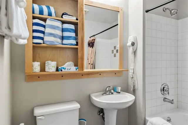 a bathroom with a sink toilet and shower