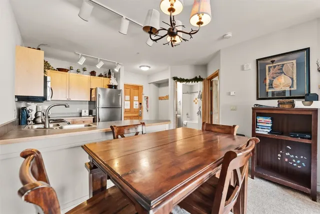 a dining room with wooden floor and large windows