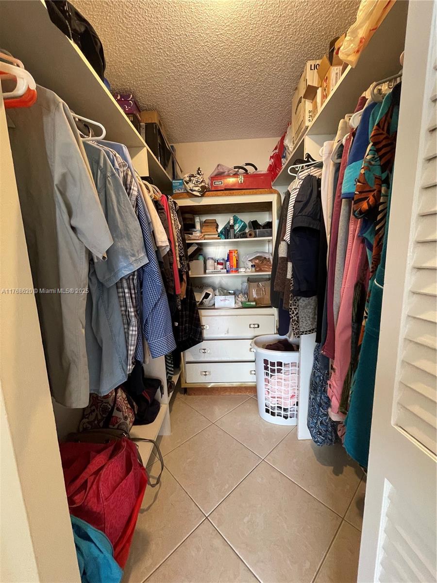 Oceanside Hallandale Beach, FL 33009 - Photo 36 of 49 a view of walk in closet with clothes and shoes