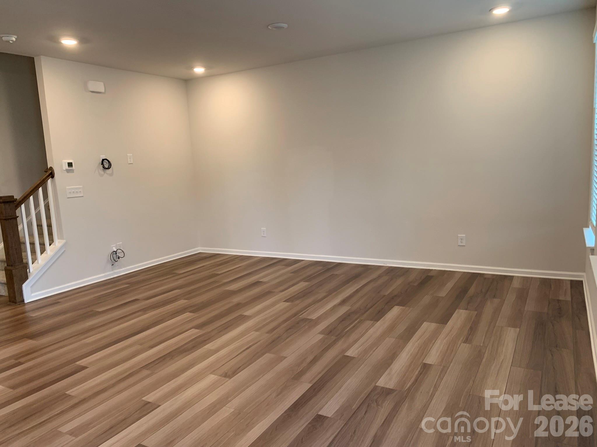 2143 Stevens Mill Road Matthews, NC 28104 - Photo 11 of 39 a view of room with wooden floor and staircase
