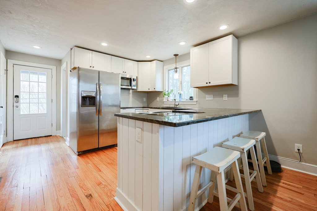 14 Cardinal Road Worcester, MA 01602 - Photo 6 of 28 a kitchen with kitchen island granite countertop a sink cabinets and wooden floor