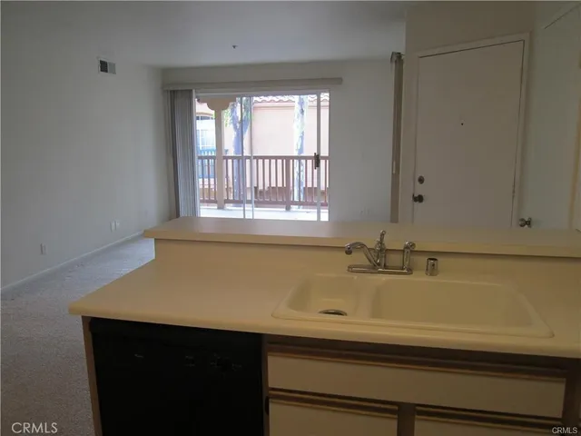 an empty room with a chandelier fan and wooden floor