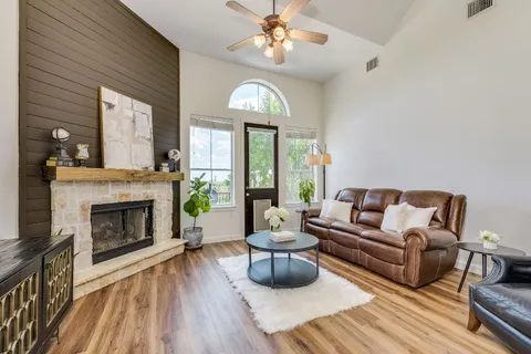 a living room with furniture a fireplace and a chandelier