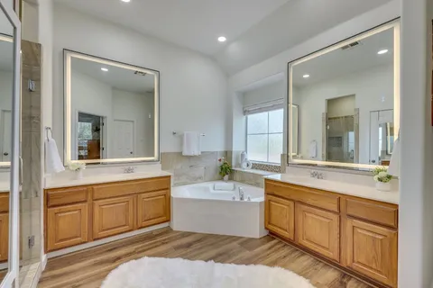 a bathroom with a sink double vanity mirror and a bathtub
