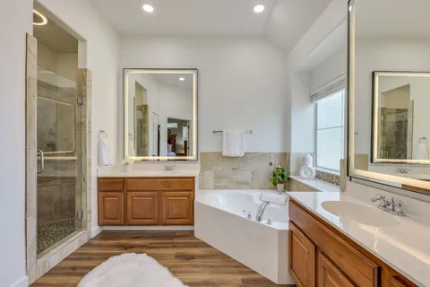 a bathroom with a granite countertop tub sink and mirror
