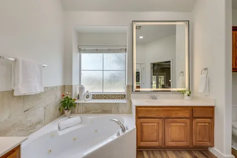 a bathroom with a tub sink and mirror