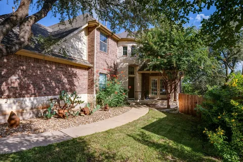 a front view of a house with a yard and a garden