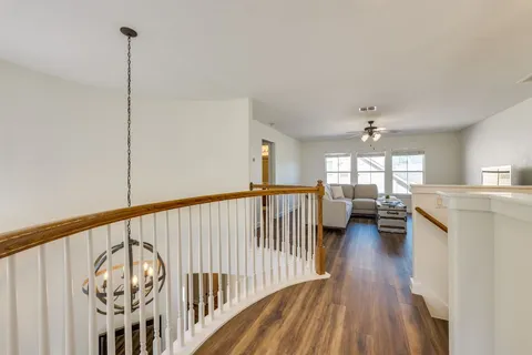 a view of a hallway with wooden floor and stairs