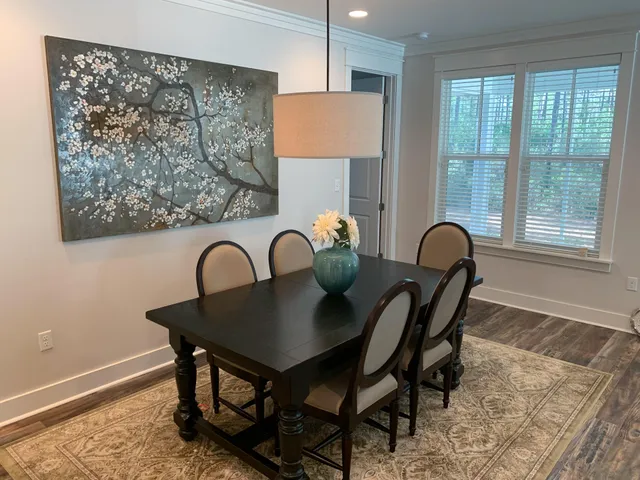 a view of a a dining room with furniture window and wooden floor