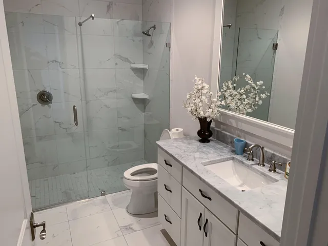 a bathroom with a granite countertop sink a toilet and shower