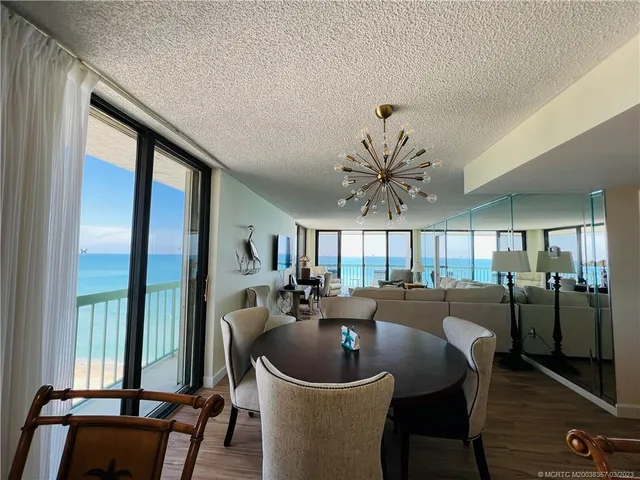 a dining room with furniture wooden floor a rug and a chandelier