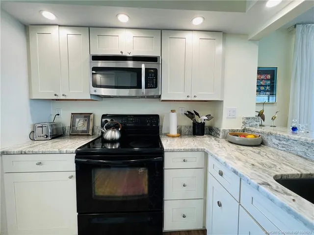 a kitchen with granite countertop a sink and cabinets