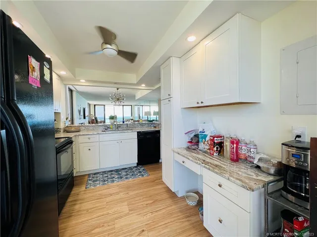 a kitchen with stainless steel appliances granite countertop a refrigerator a stove and a sink