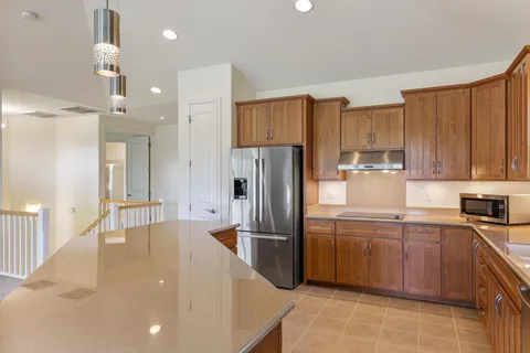 a kitchen with kitchen island a large counter top space appliances and a large window