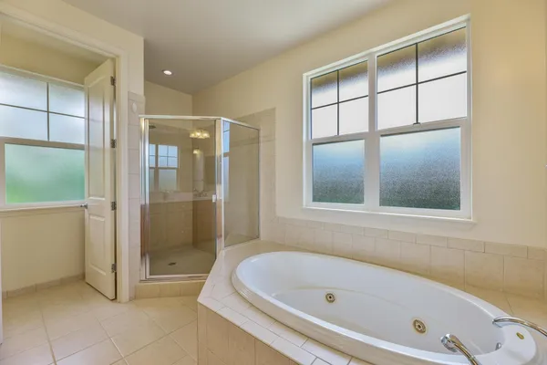 a bathroom with a tub a shower and a sink