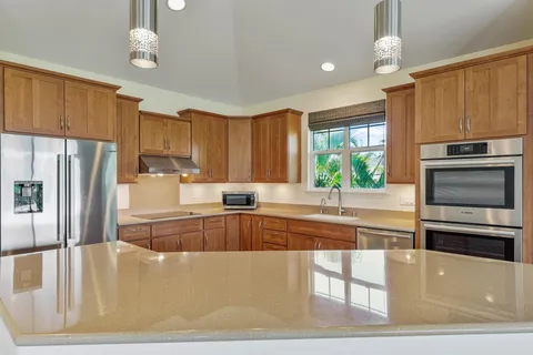 a kitchen with kitchen island a large counter top space appliances and cabinets