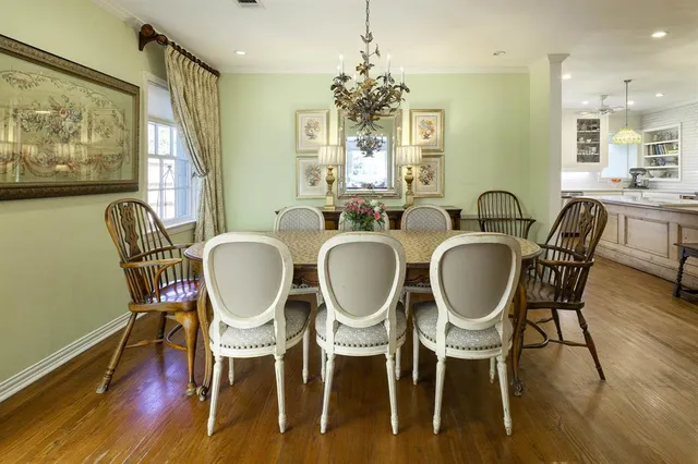 a dining room with furniture a chandelier and wooden floor