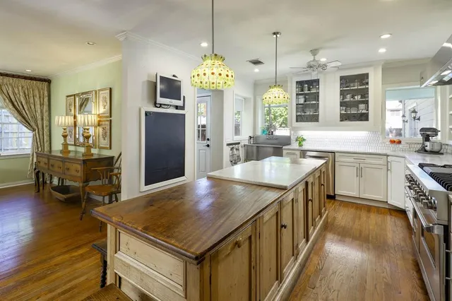 a kitchen with stainless steel appliances granite countertop center island wooden floor and a sink