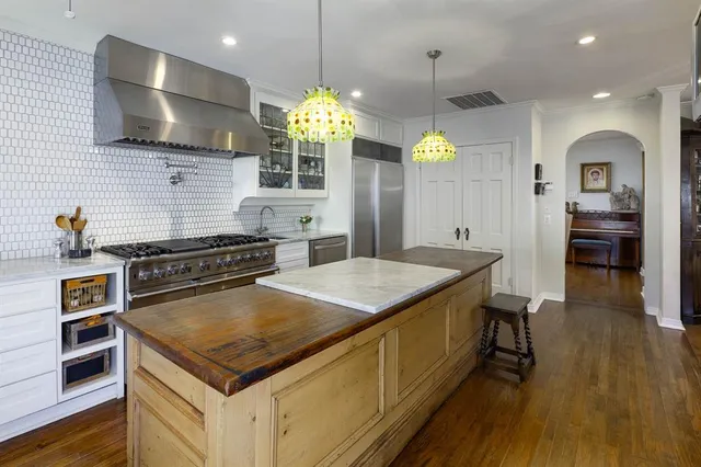 a kitchen with a stove a kitchen island a cabinets and wooden floor