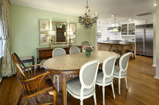 a dining room with furniture a chandelier and wooden floor