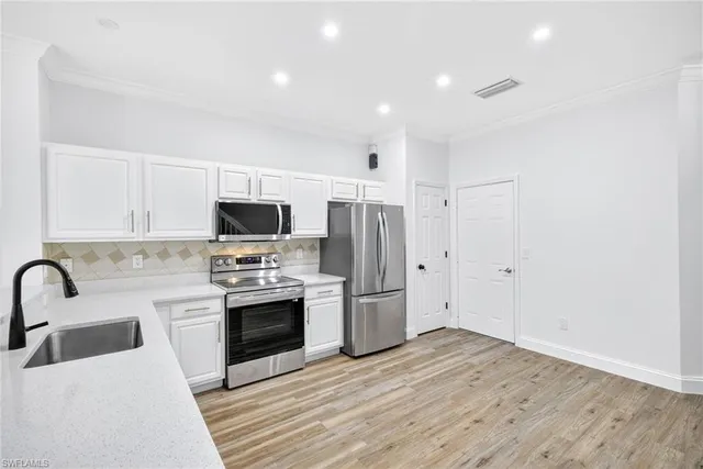 a kitchen with stainless steel appliances a stove a sink and a refrigerator