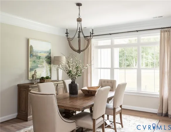 a dining room with furniture a chandelier and wooden floor