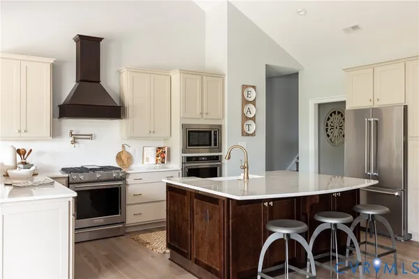 a kitchen with stainless steel appliances a stove a sink island and a refrigerator